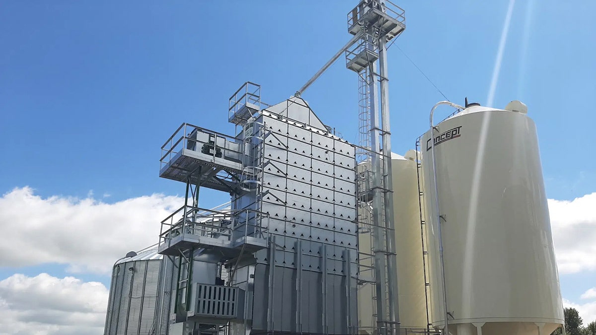 Large, state-of-the-art machinery on a modern farm, set against a clear and picturesque blue sky.