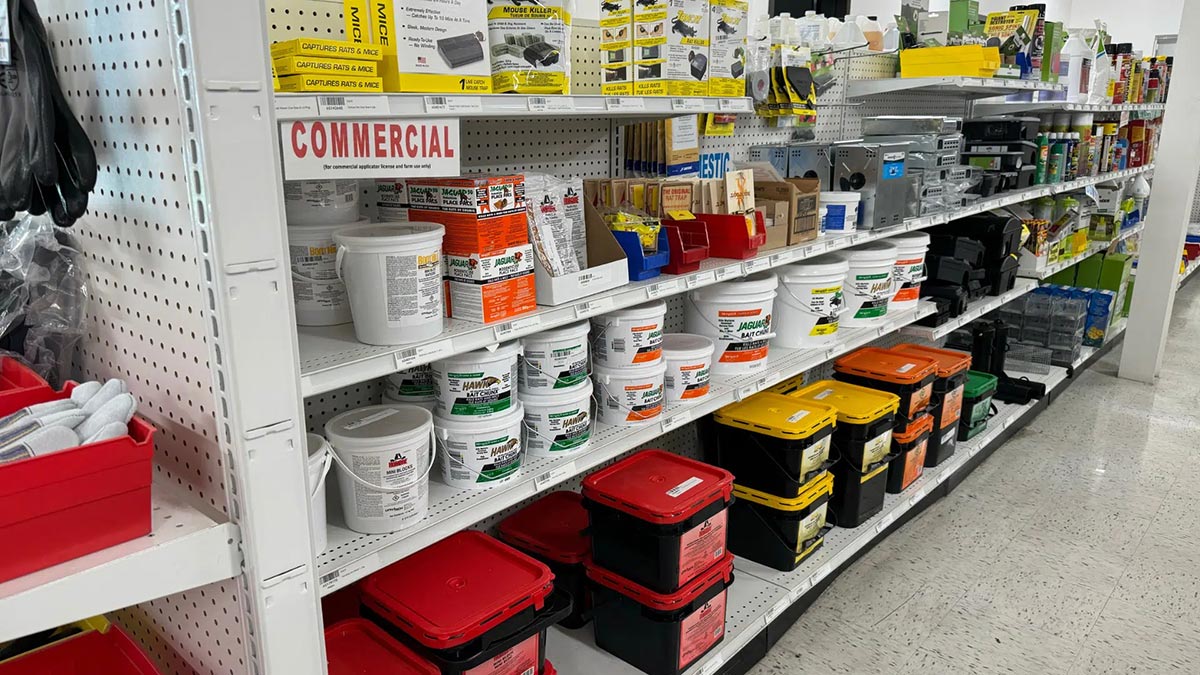 Store shelf with various pest control products, including bait and traps for rats and mice, organized by type and color.